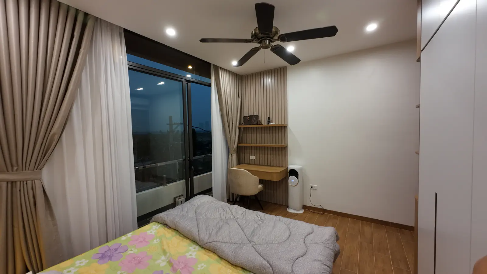 Không gian phòng ngủ có bàn làm việc và cửa kính lớn tại Long Biên